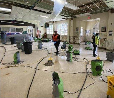 Mopping and drying the floors after a water leak.