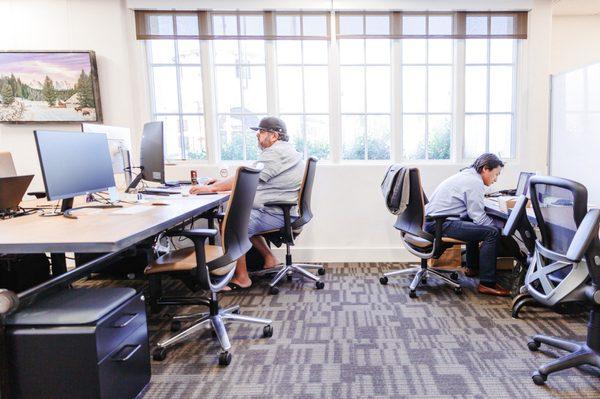 Coworkers at work in our Pod dedicated desk area.