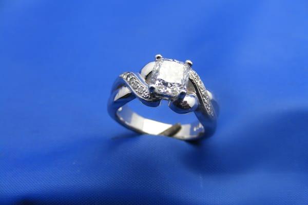 Custom ring in platinum with 1.28ct cushion center diam and woven band.