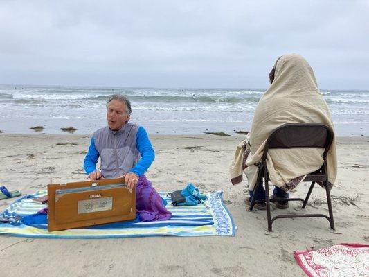 Chanting spiritual songs in preparation for meditation facing the blissful pacific ocean