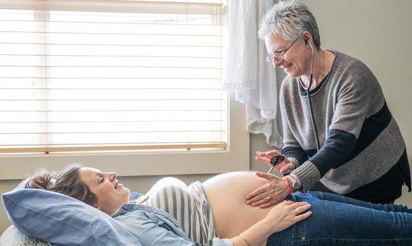 Midwife Beth Coyote listening to the fetal heart during a prenatal exam