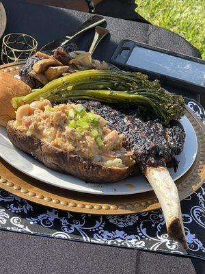 Tomahawk steak with seafood stuffed twice baked potatoes broccolini and dinner roll