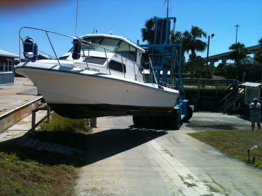 Captains Cove crew lifting a 32' Sport Craft from the water.