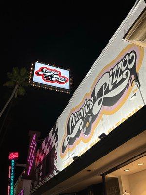 The Exterior of Licorice Pizza Records all lit up at night. It was an LA Record Store from the 70's & 80's & is Back again in Studio City CA