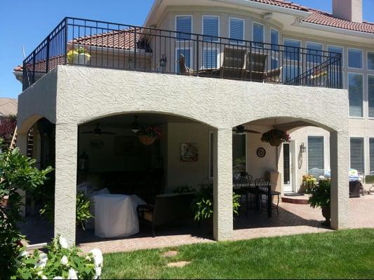 photo shows new stucco deck with wrought iron railing