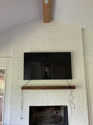 TV mounting on brick above a fireplace