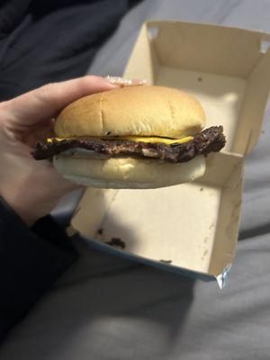 1/4 Lb Cheeseburger that's missing all the toppings except cheese and it's completely burnt