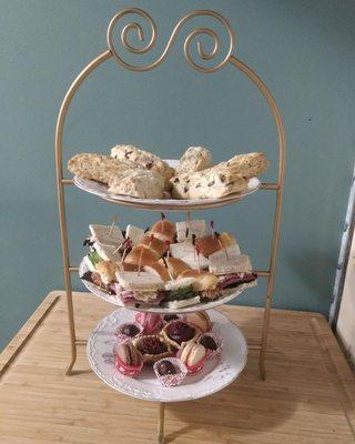 Tea tower with a formal British tea: warm scones in at least 2 flavors, 3 kinds of finger sandwiches, and sweet treats for dessert.