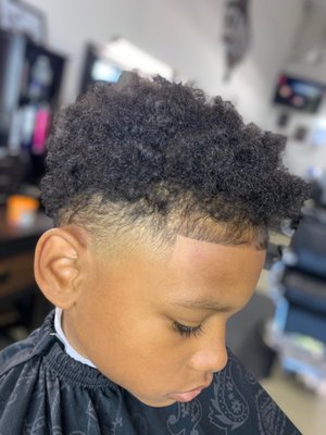 Curly top with a high fade and baby hairs lined up too sharp