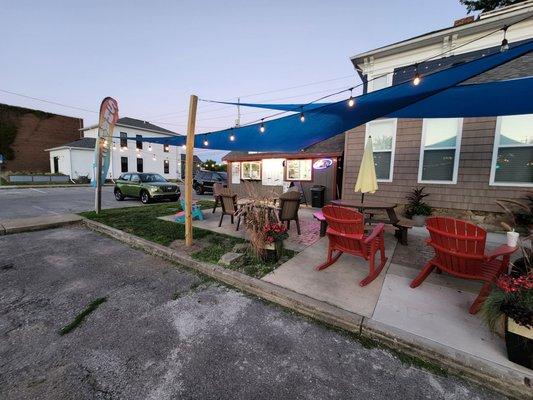 Seating area with shade sail and ambient lighting.