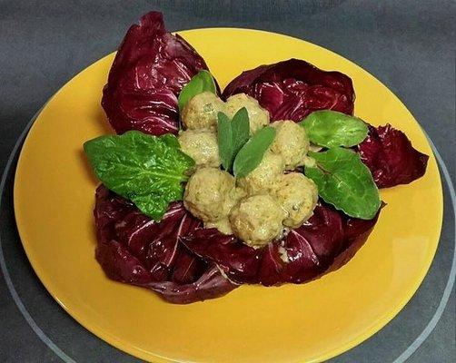 Homemade beef meatballs in a lemon and caper sauce, on a bed of Italian red chicory