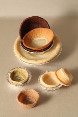 Frozen, ready-to-bake tart shells come in a variety of sizes and flavors. Tart shell tins prevent breakage during shipping.