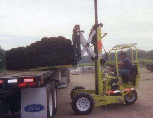 Truck mounted forklift unloading sod.