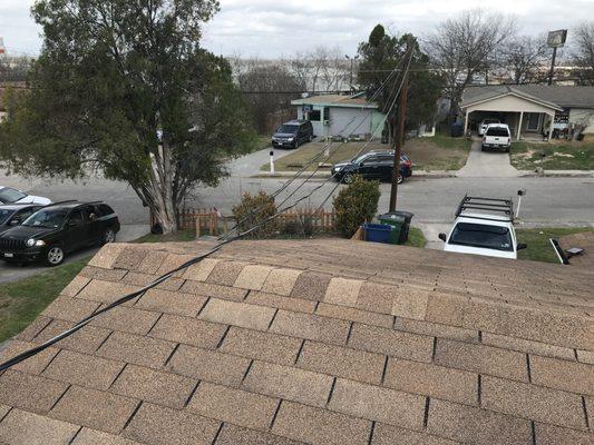 Power lines sitting on the ridge. Shingle granulation is like sandpaper rubbing against the high-voltage lines; potential problem!