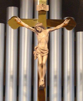 The crucifix above the altar at Immanuel Lutheran Church, with pipe organ background.