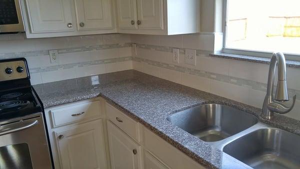 Fresh coat of paint on cabinets, granite tops with glass back-splash.