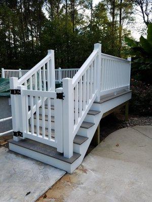 Deck wrapped around an above ground pool, with Potomac Grey decking and  vinyl accents