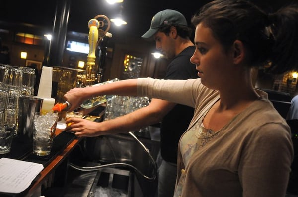 A team of course participants work together to perfect a cocktail behind the bar.