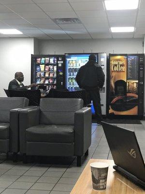 Clean, comfortable customer waiting area with complimentary hot beverage machine