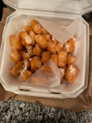 Zeppoles (fried dough) with caramel something sauce and powdered sugar