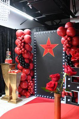 Hollywood themed backdrop and balloon garland.