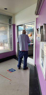 He takes his break when people arrive and waits for a line to form before coming back to assist people.