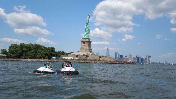 Happy people touring the Statue of Liberty's waters by hovercraft.