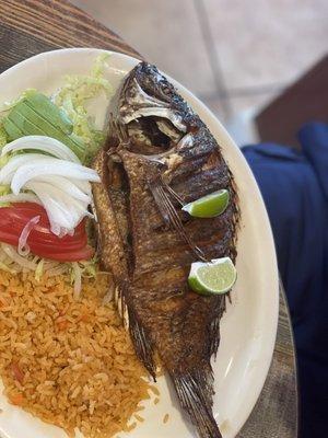 Fried whole fish with side salad and rice.