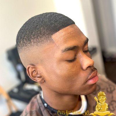 Mid-bald fade with wave length on top.