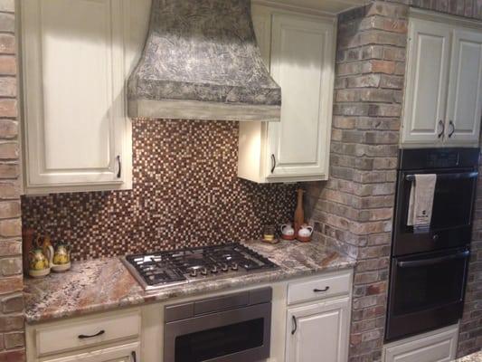 Custom built vent hood, gas cooktop, drawer microwave and glass tile basksplash