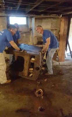 The guys removing and old furnace so we can replace it with new.