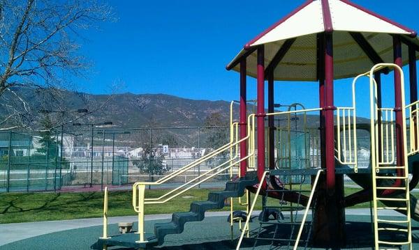 San Sevaine Park's playground structure w/ tennis courts behind it