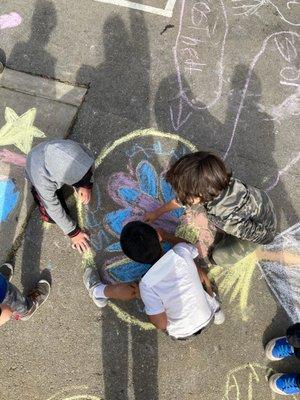 K/1 students creating chalk drawings during recess