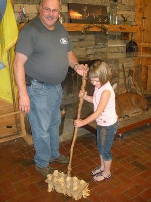 Fort Manager, Mike Woody, showing preschooler a broom that may have been used back in the day.