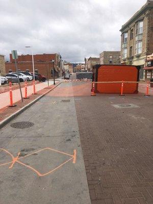 Blocked street and shoring waiting to go in the ground for deep sewer line repair on commercial street.