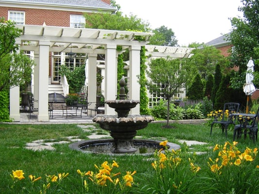 Courtyard landscape with architectural flavor iincluding pergola, garden trellis, traditional fountain and lush plantings.