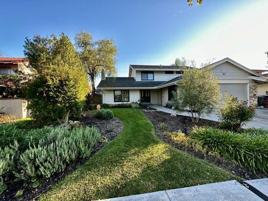 Beautiful two-story home with lush landscaping and a well-maintained yard.