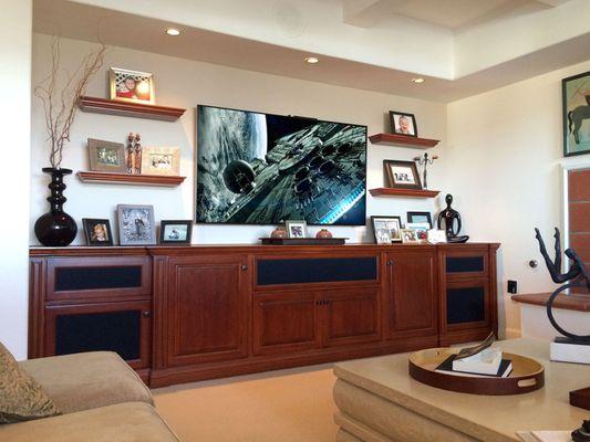 Complete home theater system including built-in home theater furniture, large screen flat panel TV, surround sound, and a single remote.