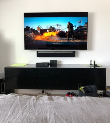 Tv mounted with sound bar and wires concealed within the drywall.