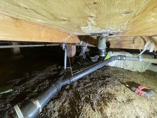 replacing old leaking pipe in crawlspace with new ABS pipe.