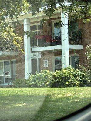 The front of the building with beautiful manicured lawn and flowers.