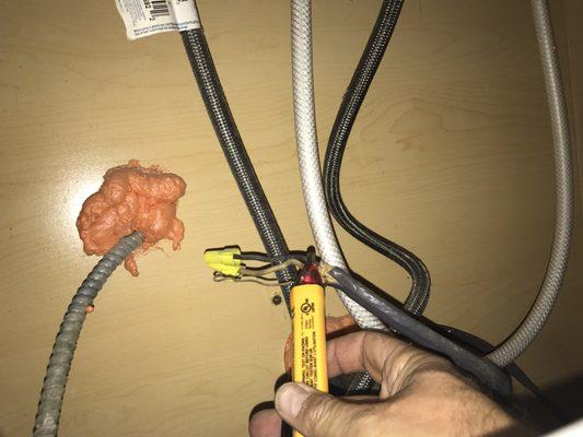 Live electrical wires capped with wire nuts under kitchen sink