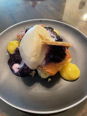 Corn bread dessert with blueberries compote vanilla ice cream and graham cracker.