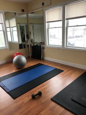 Yoga room with weights, mats, and balance balls