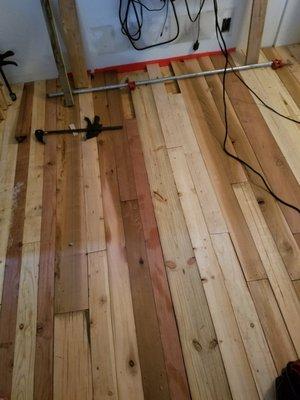 Re-purposed lumber being used as a new hard wood floor.