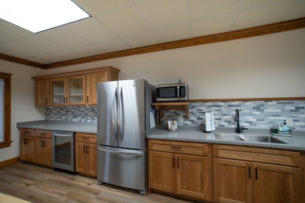 Meeting room with shared guest fridge, beverage cooler, microwave, sink, cutlery, glasses, serving ware, & dishes