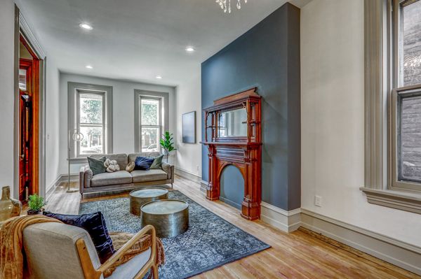 Victorian home design, refinished woodwork, accent wall, crystal chandelier. High ceilings with gray trim.