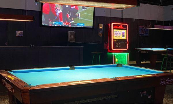 Pool table with flatscreen TV and digital jukebox.