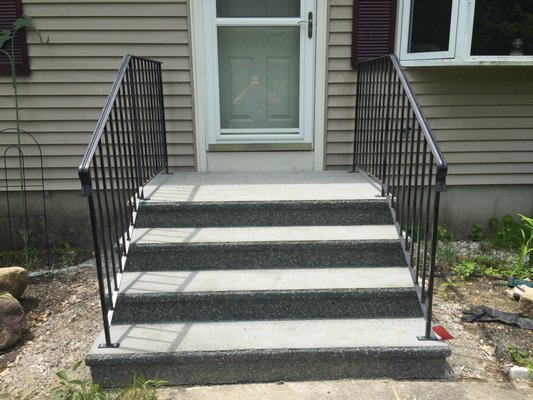 Decorative front steps with rod iron railings.