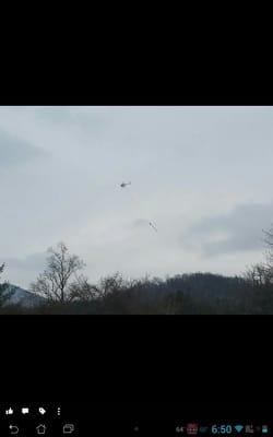 This trimming trees on the coldest day of the year & they knocked power out with the large saw hanging from this helicopter